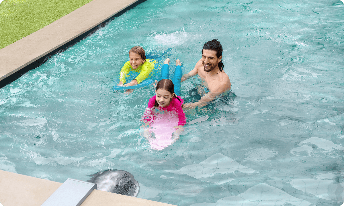 Father and children relaxing in the pool with the steady open swim flow of the iGarden Swim Jet
