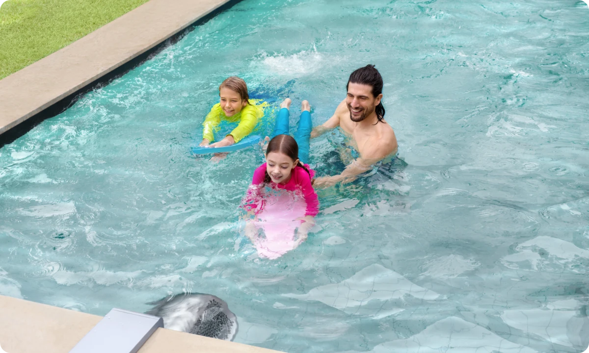 Vater und Kinder entspannen sich im Pool mit der stetig offenen Schwimmströmung des iGarden Swim Jet