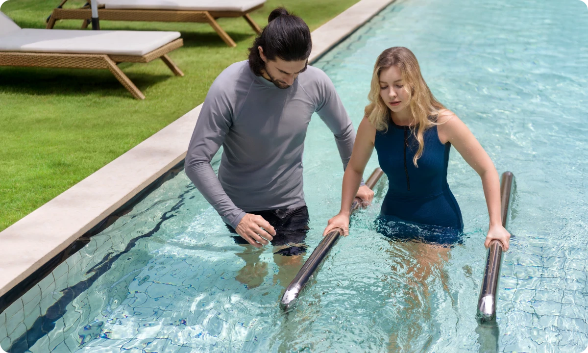 Menschen, die im Pool schwimmen und spazieren gehen, nutzen die 12 einstellbaren Strömungsmodi des iGarden Swim Jet